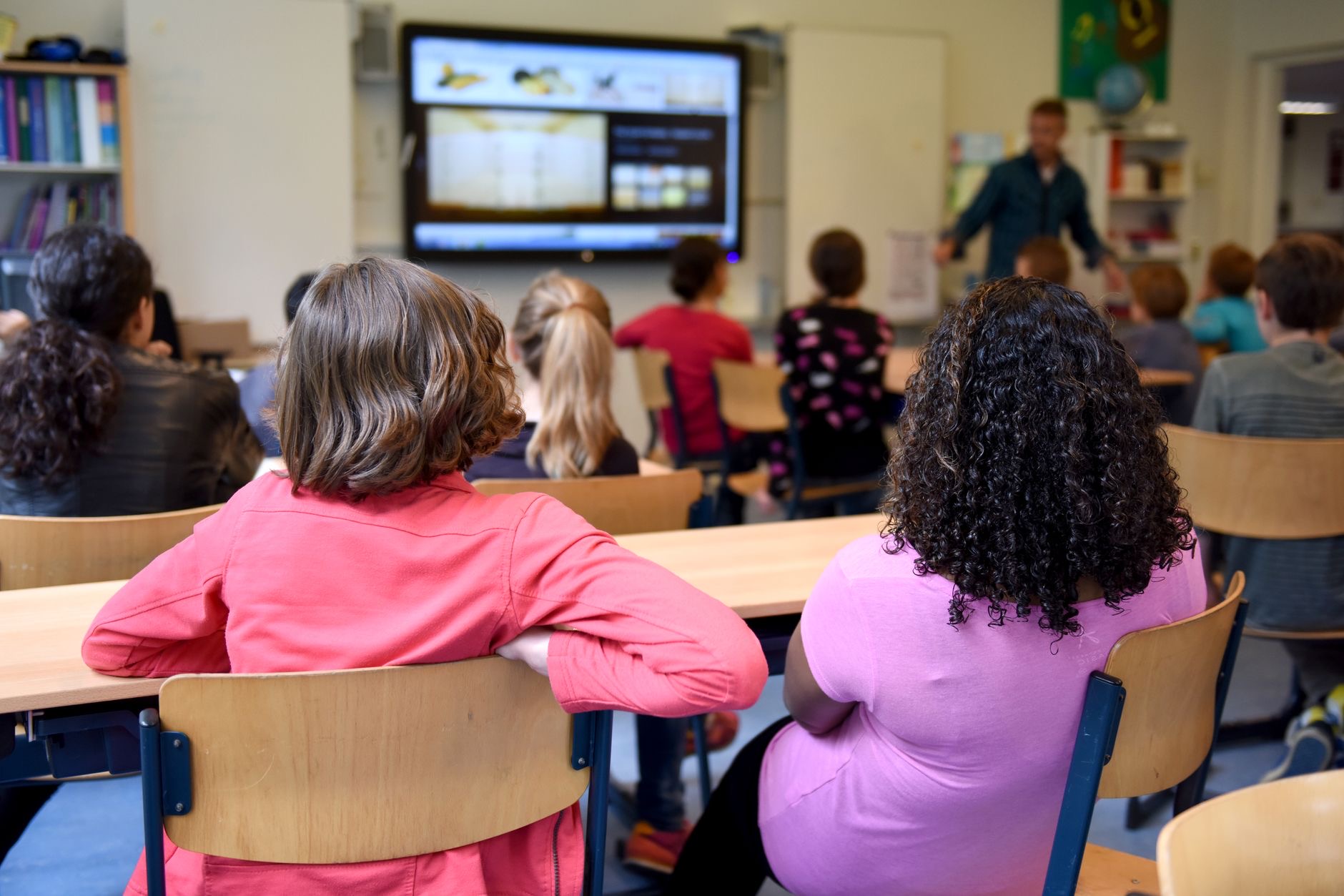A school counselor and educators meet with students in a public school setting to discuss mental health support.